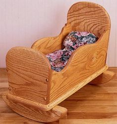 a wooden rocking toy with floral fabric on it's seat and footrests