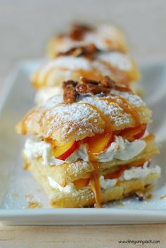 several desserts are arranged on a plate with powdered sugar and caramel topping