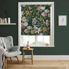 a living room with green walls and flowers on the blinds