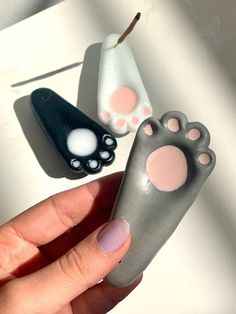 a person holding a fake toothbrush in their left hand and another one with paw prints on it