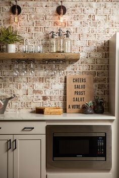 a brick wall in a kitchen with a sign on the counter and shelves above it