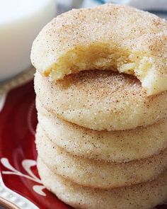 a stack of sugary donuts on a red and white plate