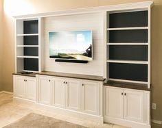 an entertainment center with white cabinets and black shelves