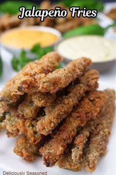 some fried food on a white plate with dipping sauces in the background and text overlay that reads jalapeno fries deliciously seasoned