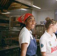 two young women in aprons are smiling at the camera while standing next to each other