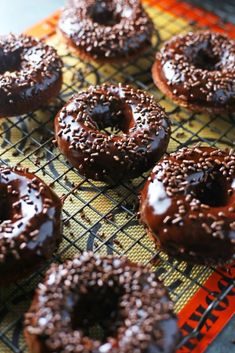 chocolate donuts with sprinkles on a cooling rack