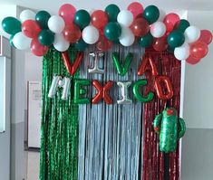 an assortment of balloons and streamers decorate the entrance to a mexican themed birthday party