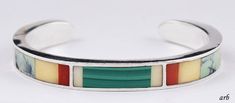 "Presented is a great American south west sterling silver cuff bracelet set with stones like coral, malachite, and turquoise. It is stamped \"R. Greene\" and \"Sterling\". At this time we cannot identify the maker. This piece features an unusual design! The band is well set with red coral, green malachite, white shell, turquoise, possibly white onyx, and brown and black wood. This is a gorgeous bracelet! The stones are well set. The bracelet is in wonderful condition. Ready to enhance your beaut Southwestern Sterling Silver Green Bracelets, Green Sterling Silver Southwestern Bracelet, Green Southwestern Sterling Silver Bracelets, Southwestern Style Green Sterling Silver Bracelet, White Onyx, Green Malachite, Gold Cufflinks, Sterling Silver Cuff Bracelet, Sterling Silver Filigree