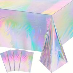 the table cloth is hologized in iridescent colors and has five napkins on it