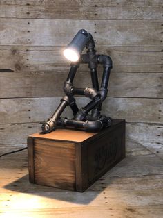 a robot lamp sitting on top of a wooden box