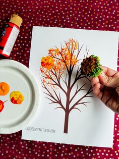 someone is painting a tree on a paper plate