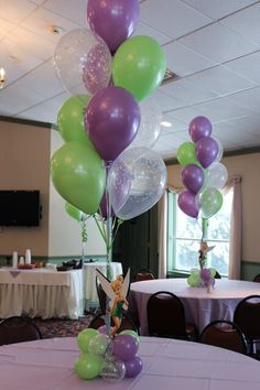 balloons and streamers are on the table at a birthday party in a banquet hall