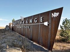 a large sign that is on the side of a hill in front of some trees