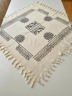 a white table topped with a black and white rug