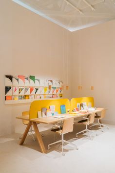 two yellow chairs sitting next to each other in front of a table with pictures on it