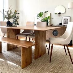 a wooden table with two chairs and a bench next to it in a living room