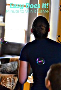 a woman is blowing bubbles in the living room