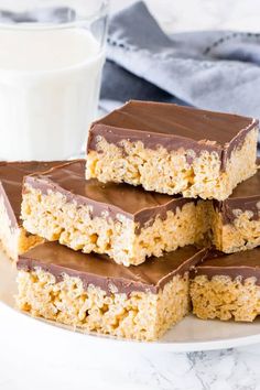 chocolate and oatmeal bars stacked on top of each other with a glass of milk in the background