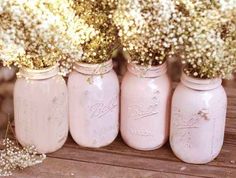 four mason jars filled with baby's breath flowers