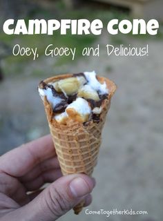 a hand holding an ice cream cone with toppings on it and the words campfire cone ooey, gooey and delicious