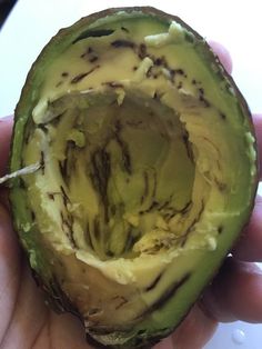 the inside of an avocado being held in someone's hand