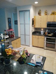 a kitchen filled with lots of counter top space and stainless steel refrigerator freezer next to it