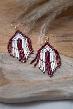 ↠ DESCRIPTION OF THE JEWELRY ↞ These handwoven Hakan earrings are a celebration of Native American art and culture. Each pair, adorned with fringes in burgundy, pale pink and white hues, is meticulously crafted with high-quality Miyuki beads. The patterns, inspired by traditional Native American designs, add an authentic touch to this unique jewelry. ↠ SPIRITUAL MEANING ↞ Wearing these earrings means reliving the history and tradition of indigenous peoples. Each pattern has its own meaning, ener Handmade Beaded Drop Earrings For Celebration, Artisan Beaded Dangle Earrings For Festive Occasions, Handwoven Teardrop Jewelry As Gift, Elegant Handwoven Beaded Earrings As Gift, Elegant Handwoven Beaded Earrings For Gift, Elegant Red Handwoven Jewelry, Jewelry Spiritual, Earrings Native American, Native American Design