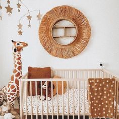 a giraffe standing next to a baby crib in a room with stars on the wall