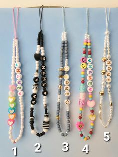 several different necklaces hanging on a wall with the numbers 1, 2, 3, 4 and 5 attached to them