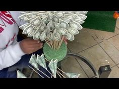 a man is making money flowers out of dollar bills