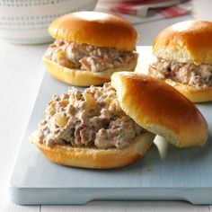 four sandwiches with meat in them on a cutting board