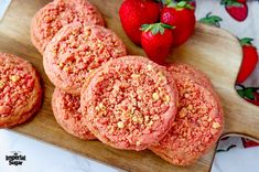 strawberry shortbread cookies on a cutting board with strawberries in the background