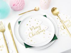 a white plate topped with a christmas tree next to gold utensils and napkins