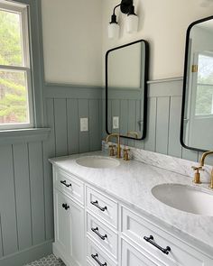 a bathroom with double sinks and two mirrors on the wall next to eachother