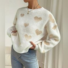 a woman wearing a sweater with hearts on it