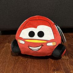 a red car shaped pillow sitting on top of a wooden table