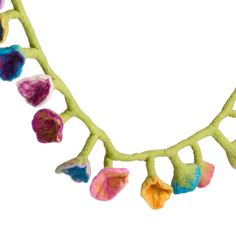 a green branch with multicolored flowers hanging from it's end, on a white background