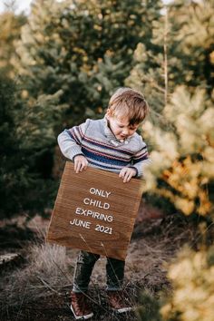 a young boy holding a sign that says only child exting june 2012