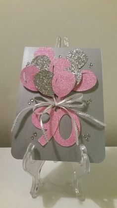 a card with pink and silver hearts on it, in the shape of a heart