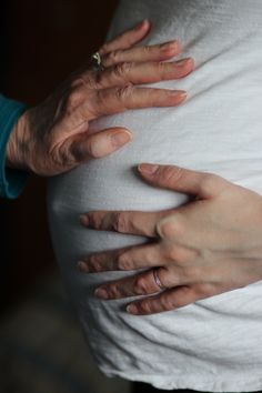 two hands on the belly of a pregnant woman