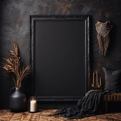 a black frame sitting on top of a wooden floor next to two vases and a candle