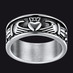 a silver ring with a heart in the center and two hearts on it's sides