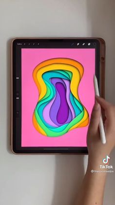 a person is drawing on an ipad with a white pen in their left hand,