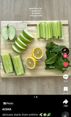 a wooden cutting board topped with cucumbers and lemons