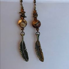 Handmade By Me, Round Sandstone Beads And Bronze Feather Earrings. 3 3/4” Long. Posts Are Lead Free Brown Adjustable Earrings With Natural Stones, Bohemian Brown Wire Wrapped Beaded Earrings, Adjustable Bohemian Brown Beaded Earrings, Elegant Brown Metal Beaded Earrings, Brown Metal Beaded Dangle Earrings, Brown Metal Beaded Earrings With Ear Wire, Adjustable Brown Beaded Earrings With Dangling Beads, Adjustable Nickel-free Bronze Beaded Earrings, Adjustable Nickel Free Bronze Beaded Earrings