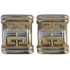 pair of gold toned cufflinks with greek writing on the front and back ends