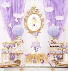 an image of a baby shower party with purple and gold decorations on the table, hot air balloons in the background