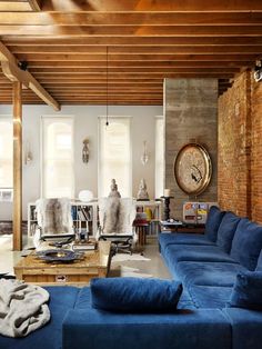 a living room filled with furniture and a large clock mounted to the side of a wall