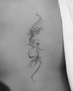 the back of a woman's stomach with two fish on it