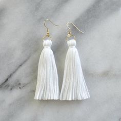 By popular demand, finally...white tassel earrings from Libby & Smee! These handmade tassel earrings will make a big style impact, whether you’re wearing them with jeans and a t-shirt or with a dress. At less than one-tenth of an ounce, Libby & Smee statement earrings feel virtually weightless!+ super lightweight cotton tassel in white+ gold-plated stainless steel ear wire hooks (lead-free and nickel-free)+ comes with plastic earring back for security+ LONG is 3.25 inches and MINI is 2.5 White Bohemian Fringe Earrings, Bohemian White Tassel Earrings For Pierced Ears, Elegant White Fringe Earrings, Minimalist Tassel Earrings, Elegant White Tassel Earrings For Pierced Ears, Elegant White Tassel Earrings, White Dangle Tassel Earrings With Latkans, White Dangle Tassel Earrings As Gift, White Fringe Tassel Earrings As Gift